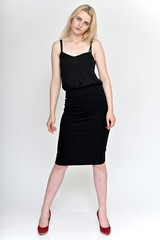 Full-length vertical portrait of a cute blonde student girl, a young woman in a black dress with beautiful curly hair on a white background in different poses. Beauty, brightness, emotions.