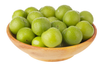 heap green cherry-plum in wooden plate isolated on white background