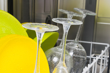 background of clean colorful dishes inside the dishwasher