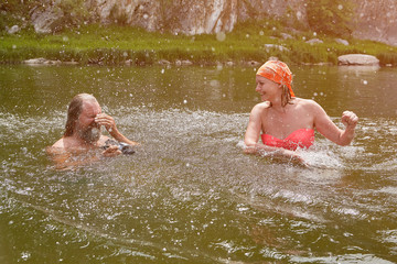 Married couple swimming in the river during vacation.