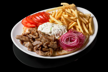 Close up of traditional Greek dish called Gyros pita and fries or Greek pie with roast beef salad and spices