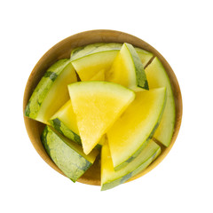 heap of slices yellow watermelon in wooden plate isolated on white background