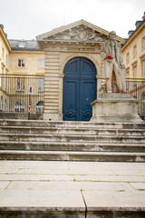Fototapeta na wymiar Claude Bernard statue in front of the main entrance to the College de France in Paris