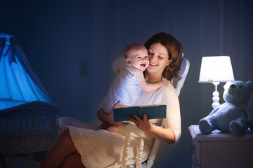 Mother reading a book to little baby
