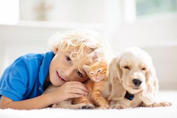 Child, dog and cat. Kids play with puppy, kitten.