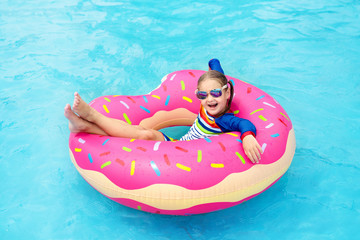 Child in swimming pool on donut float