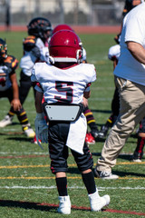Youth football player number 5 stands on turf ready to play.