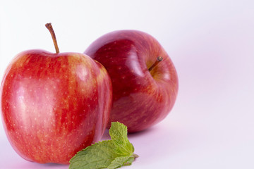 red apples on white background, mint leaves, group of two