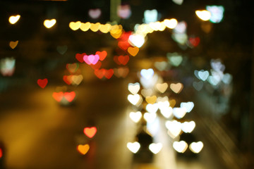 Heart-shaped bokeh from heavy traffic lights.Valentines.Abstract heart shaped bokeh of multi colored.Christmas lights day background.