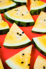 cut off triangular slices of ripe yellow watermelon on white background