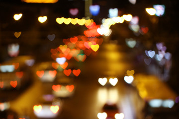 Multicolored bokeh heart background image.From traffic lights on roads.