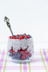 Chia seed pudding with blueberries and red currant berries in a glass