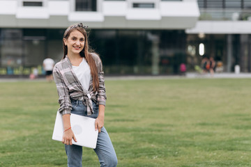 Portrait of attractive young woman on green grass in park