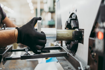 Close up shot of manual worker hands. Factory for industrial production of electric housings and surge arresters.