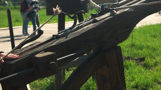 Man using ancient crossbow in the old fortress. Close up kid shooting with antique wooden weapon. Vintage ballistic device.