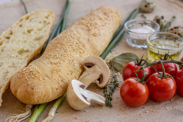 bread composition with herbs and vegetables on a baker's table