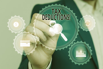 Handwriting text Tax Deductions. Conceptual photo reduction income that is able to be taxed of expenses Male human wear formal work suit presenting presentation using smart device