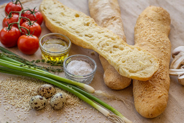 bread composition with herbs and vegetables on a baker's table