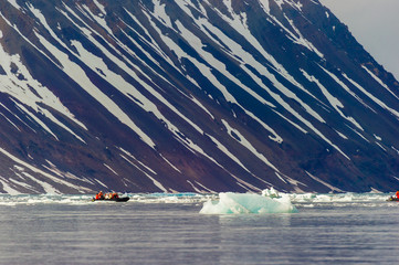 HORNSUND, SVALBARD, NORWAY – JULY 26, 2010:  Tourists in ocean rafts, Hornsund, Norway