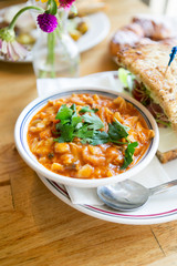 Close up of minestrone soup with california club sandwich on cafe table