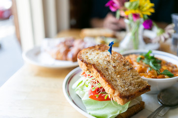 California club sandwich with side of minestrone soup on table in cafe, close up, copy space