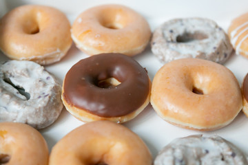 Top view of box of a dozen mixed donuts, close up, white background