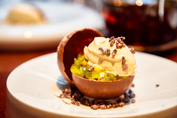Ice cream with fruit in the chocolate sphere