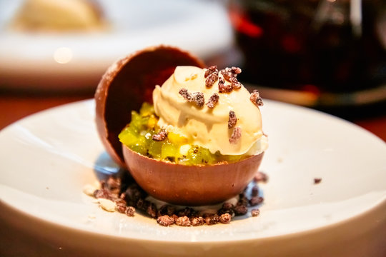Ice cream with fruit in the chocolate sphere