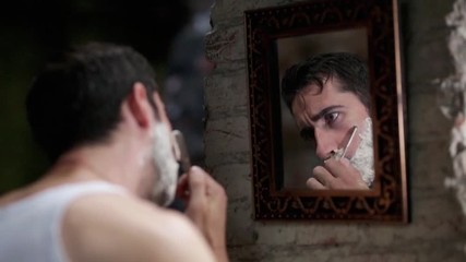 Serious boy shaving his beard