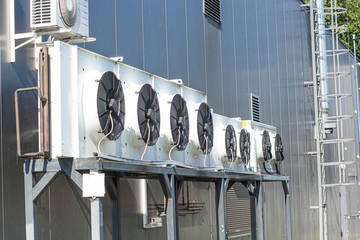 cooling fans hang on the wall of the building