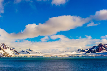 The end of a glacier in the Arctic Circle where it falls into the Arctic Ocean in Hornsund,...