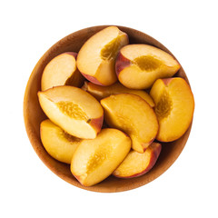 heap of slices peach in wooden plate isolated on white background. top  view
