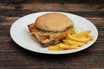 Hamburger with meat, tomato, lettuce and french fries.