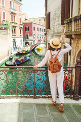 young pretty woman traveler standing at venice bridge cross canal