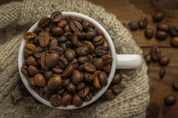 Fototapeta premium Cup with coffee grains on wooden table
