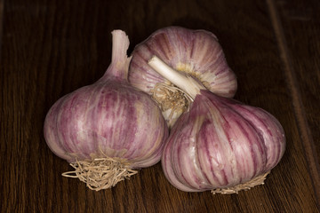 heap of fresh red garlic bulbs on wooden background