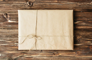 Overhead view of a single holiday package wrapped with eco friendly craft paper and tied with...