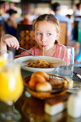 Little girl eating spaghetti