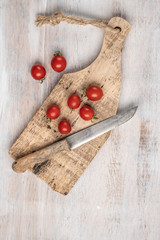 Fototapeta na wymiar ripe cherry tomatoes and knife on a wooden table