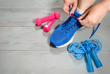 Woman a sportsman tie a cords on her sneakers.