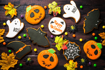Halloween Gingerbread Cookies - pumpkin, ghosts, bat, on woden table.