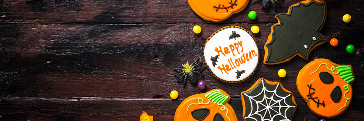 Halloween Gingerbread Cookies - pumpkin, ghosts, bat, on woden table.