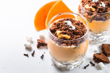 Halloween sweet dessert from cream pumpkin and chocolate.