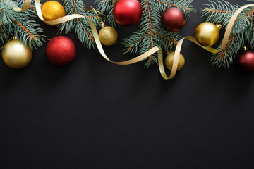 Black Christmas background with golden and red decorations, baubles, fir tree branches. Christmas holiday celebration, winter, New Year concept. Christmas banner mockup, greeting card template.