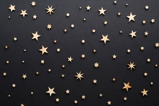 Christmas composition. Handmade wooden stars on black background . Christmas eve, dark night, Christmas decorations concept. Flat lay, top view, copy space