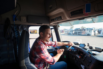 Professional truck driver with smile driving truck and delivering goods on time. Fast...