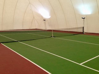 empty indoor tennis court ready for players