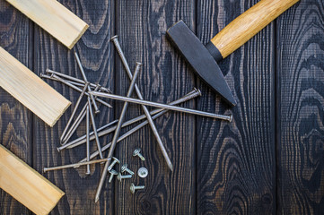 Tools for carpentry and accessories on a black wood background.