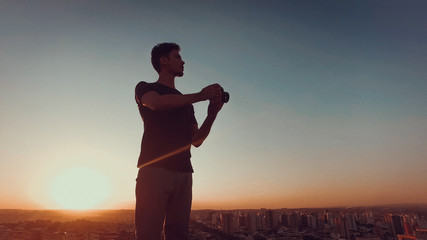 Fototapeta premium Photographer on top of the building at sunset