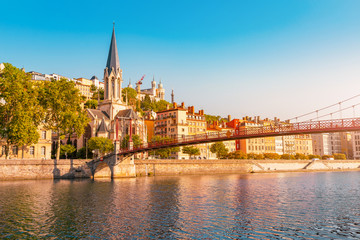 Early morning cityscape view of St Georges pedestrian bridge in Lyon city with old church on the opposite bank of the river. Travel destinations in France - obrazy, fototapety, plakaty